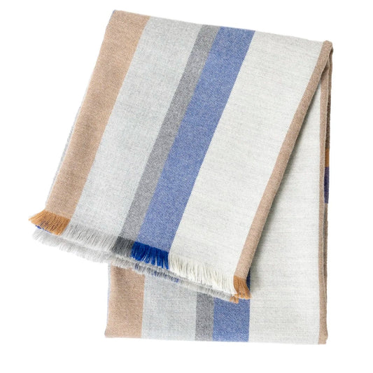 The Bolsa Throw by Dove & Donkey is a modern plaid blanket with beige, gray, and blue vertical stripes and fringe edges, neatly folded and displayed on a white background.