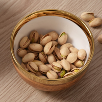 Madera Gold Snack Bowl with gold embellished rim with pistachios on top.