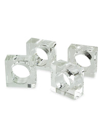 The Tizo Crystal Cube Napkin Ring Set of 4 features clear, rectangular acrylic napkin rings arranged together on a white background. Each modern table accessory has a circular opening in the center for holding napkins, reminiscent of crystal napkin rings. Their acrylic construction beautifully reflects light, enhancing the sleek and contemporary look.