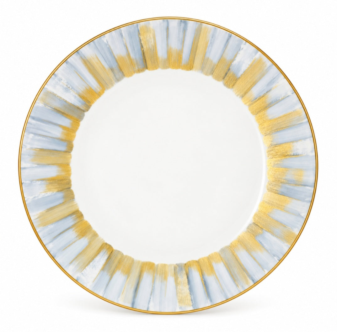 Marie Daâge Panache white Limoges porcelain dinner plate with a gold-rimmed edge and a border of vertical, brushed blue and gold stripes.