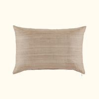 The Kasai Pillow 16 x 24 by Threads Soft Goods is a rectangular beige throw pillow with subtle horizontal stripes, inspired by Kuba cloth designs, shown against a plain off-white background.