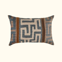 The Kasai Pillow 16 x 24 from Threads Soft Goods features a geometric maze-inspired design in blue, beige, and brown with two vertical brown textured stripes and decorative trim, handcrafted and inspired by Kuba cloth pillows.