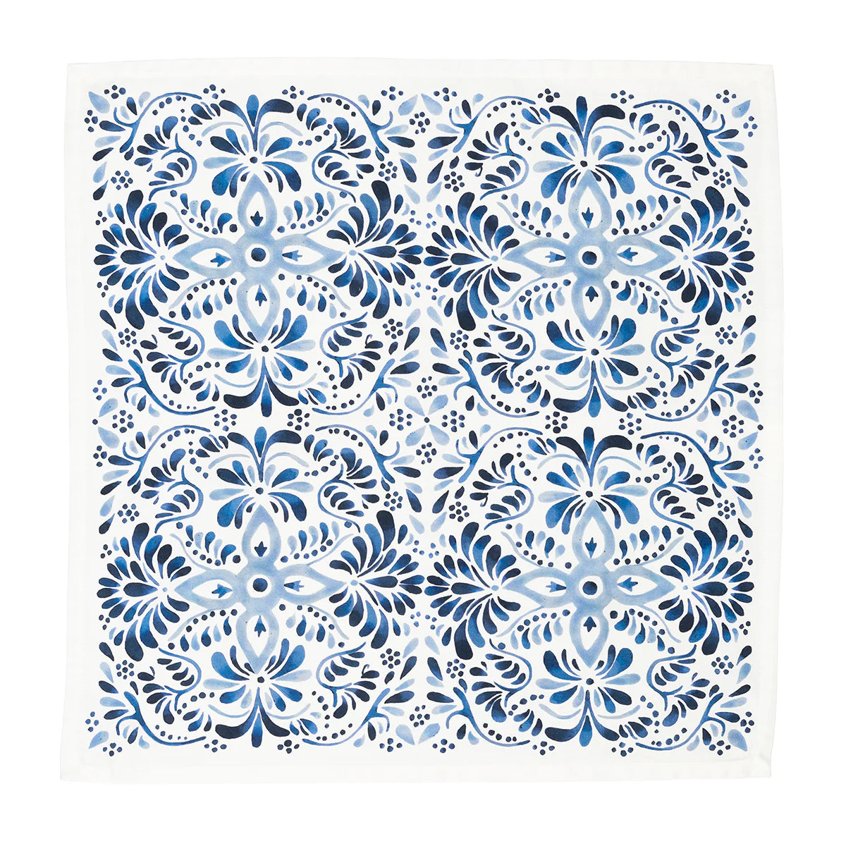 The Juliska Iberian Napkin Indigo - Set/4 features a symmetrical blue and white floral design inspired by the Iberian Journey, with intricate patterns reminiscent of cobalt blue tiles on a crisp white background.