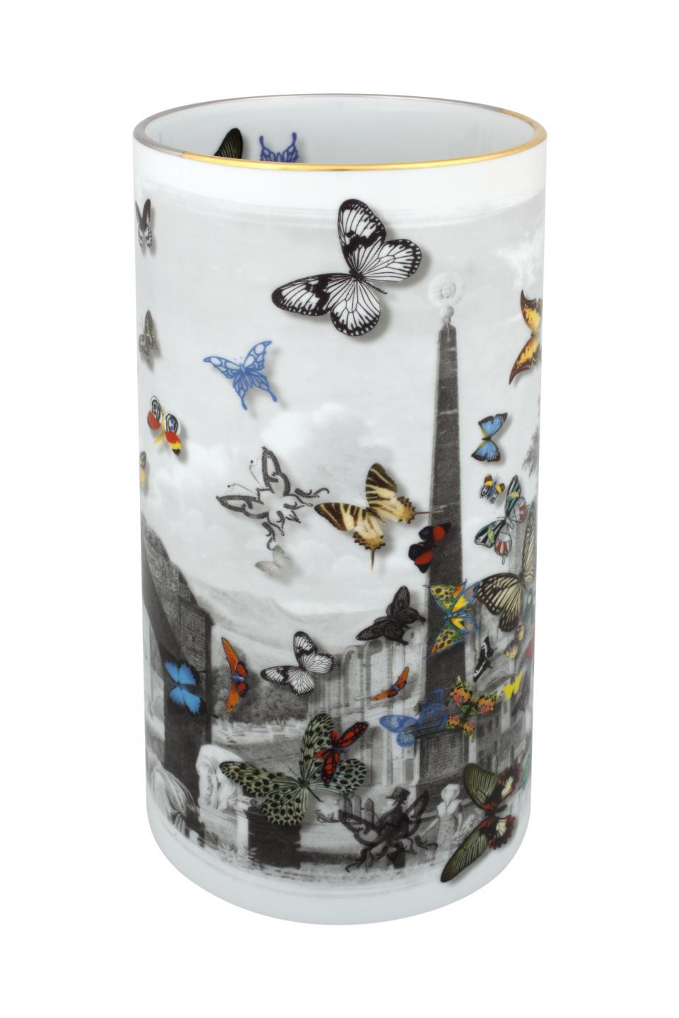 The Large Forum Vase by Christian Lacroix for Vista Alegre is a cylindrical porcelain vase adorned with a black-and-white cityscape and vibrant, multicolored butterflies of various sizes. A delicate gold line accents the rim, lending the piece an elegant finish characteristic of Vista Alegre craftsmanship.
