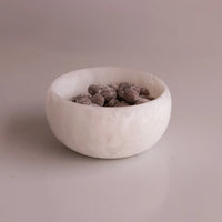 The Beatriz Ball Resin Sorbet Mini Bowl - Coconut holds cocoa-dusted chocolate almonds and rests on a smooth, light-colored surface with a plain background.