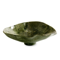 The Beatriz Ball Resin Malachite Oval Bowl Green features a wide, shallow design with an irregular, organic shape and textured surface reminiscent of malachite. Perfect for serving salad on a stylish dining table, this dark green ceramic bowl is showcased against a plain white background.