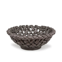 The Skyros Woven Basket - Round-15" is a dark gray, handwoven basket featuring thick interlaced strands and a matte finish, crafted by Portuguese artisans. Shown on a white background.