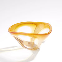 The Enigma Bowl - Amber by Global Views / Surya is a handblown art glass piece featuring a transparent amber hue, smooth curved edges, and an organic asymmetrical shape. Set against a plain white background, this bowl functions as both a striking decorative catchall and an elegant accent for any space.
