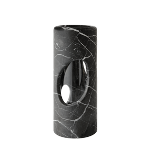The modern cylindrical black marble side table with white veining and an oval cutout pairs elegantly with the Pietra Marble Vase by Greg Natale, creating a chic minimalist display against a plain white background.