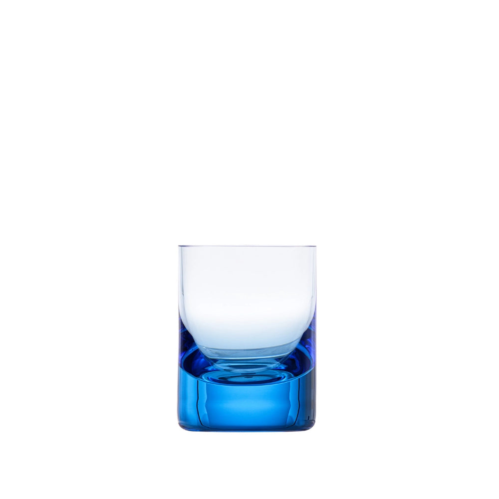 The Moser Whiskey Set Shot Glass is a clear glass tumbler with a thick blue base, displayed against a plain white background and crafted from hand-blown glass for an elegant finish.