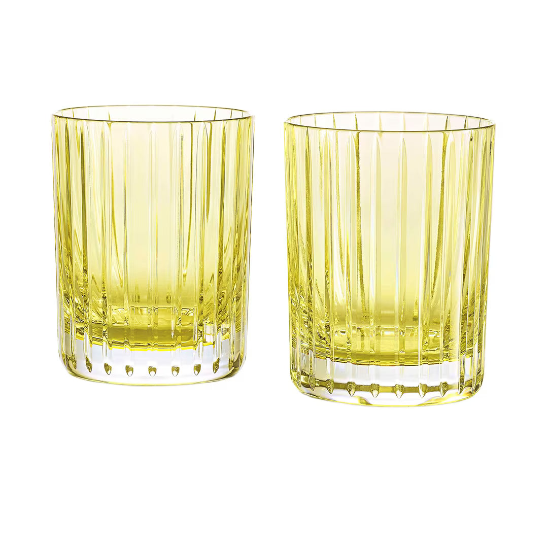 Two pastel yellow crystal glass tumblers from the Baccarat Harmonie Colors of Joy set, featuring vertical ridges, are placed side by side on a white background—an exquisite example of Baccarat barware.