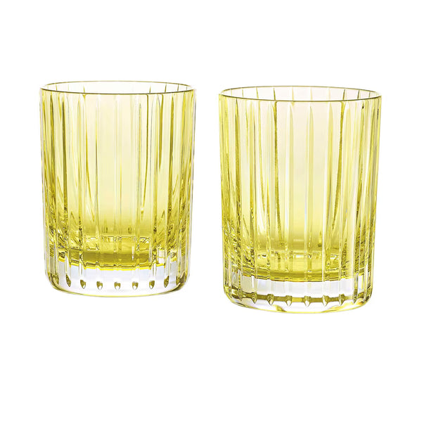 Two pastel yellow crystal glass tumblers from the Baccarat Harmonie Colors of Joy set, featuring vertical ridges, are placed side by side on a white background—an exquisite example of Baccarat barware.