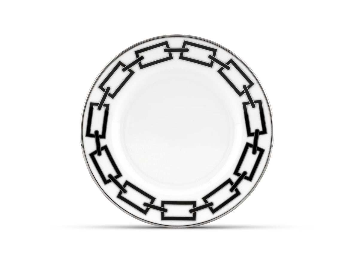 Experience modern elegance with the Ginori 1735 Catene Nero Dinnerware. This white ceramic plate showcases a striking black geometric pattern of interlocking rectangles along the rim, creating a contemporary and stylish border. The center remains plain and unadorned for a refined finish.