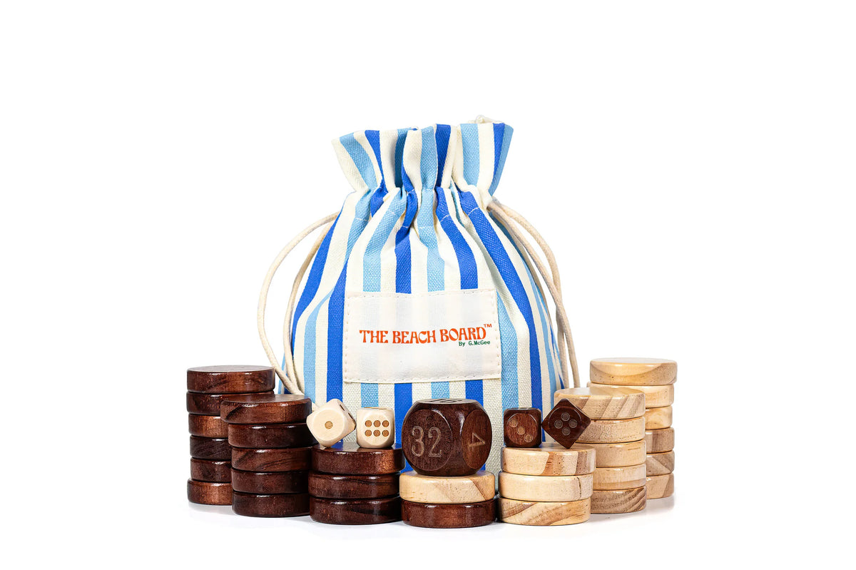 A blue-and-white striped drawstring bag labeled Southampton Beach Backgammon by G. McGee is surrounded by stacks of dark and light wooden backgammon pieces and dice, neatly displayed on a white background.