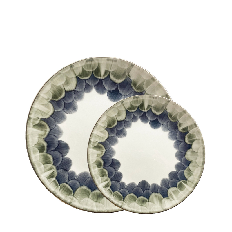 Two Marie Daâge Cercle d'Ecailles Dessert Plates, crafted in ceramic with hand-painted blue and green scalloped rims, overlap on a white background—showcasing the brand’s elegant artistry.