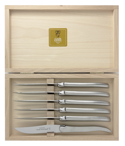 A set of six Claude Dozorme Inox Brillant Steak Knives displayed in an open wooden presentation box.