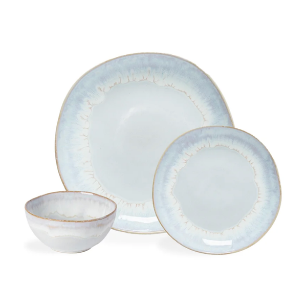 Three pieces from the Brisa Sal Dinnerware collection by Casafina/Costa Nova—crafted in Portugal from stoneware—include a bowl, a large plate, and a small plate, each featuring organic shapes and a light blue-and-white glazed finish with subtle brown edging, elegantly displayed against a white background.