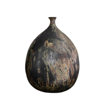The Devenir 1 Vase by CDMX / MASA TALLER is a dark, round handcrafted piece with a narrow, slightly flared neck, highlighted by an abstract marbled pattern in earthy tones of brown, green, and black. This sculptural vase exemplifies exceptional artisanal technique in both its design and finish.