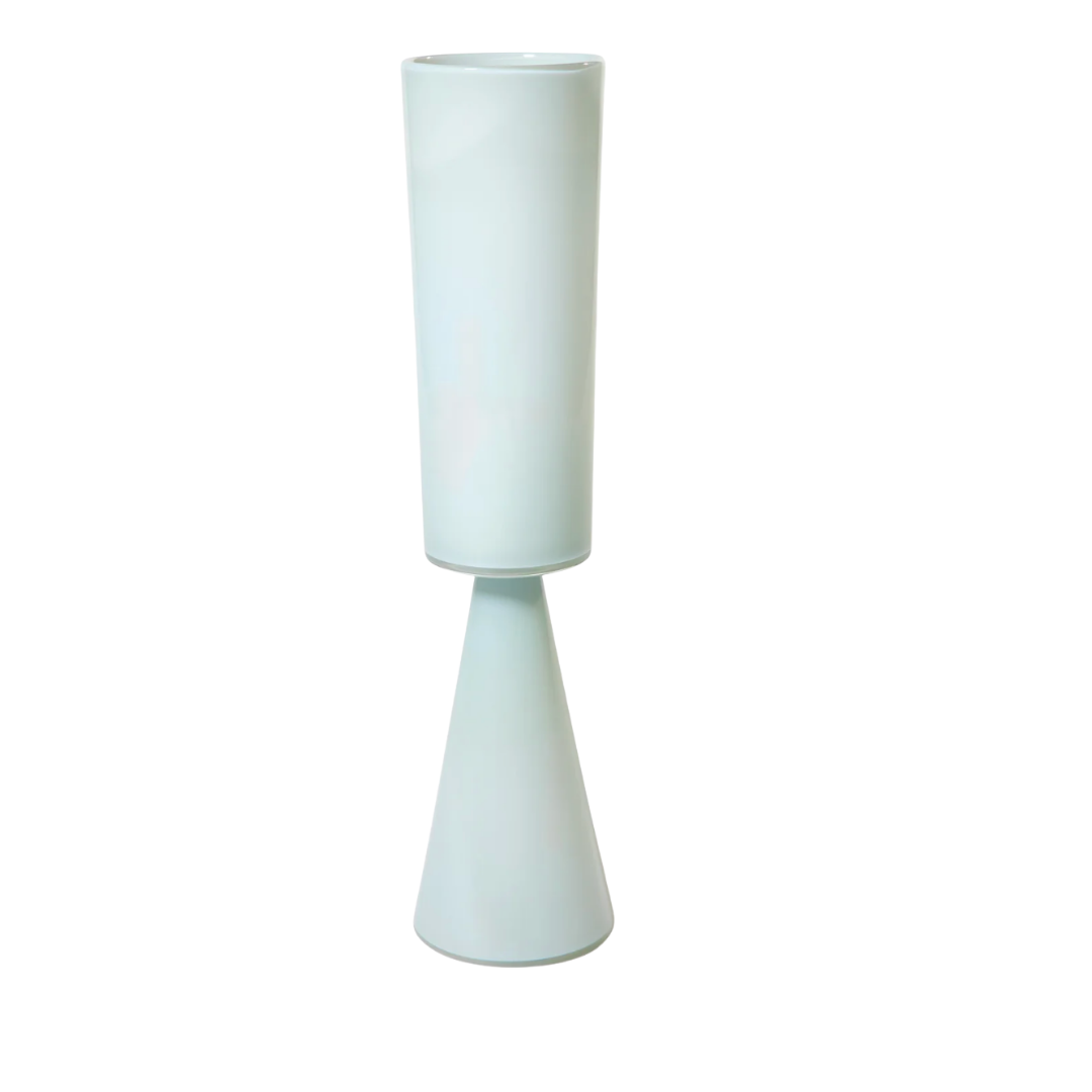 The Fiorelli Vases Ash by Current Home NY is a modern, minimalist light blue vase with a cylindrical top and cone-shaped base, ideal for showcasing architectural floral arrangements on a white background.