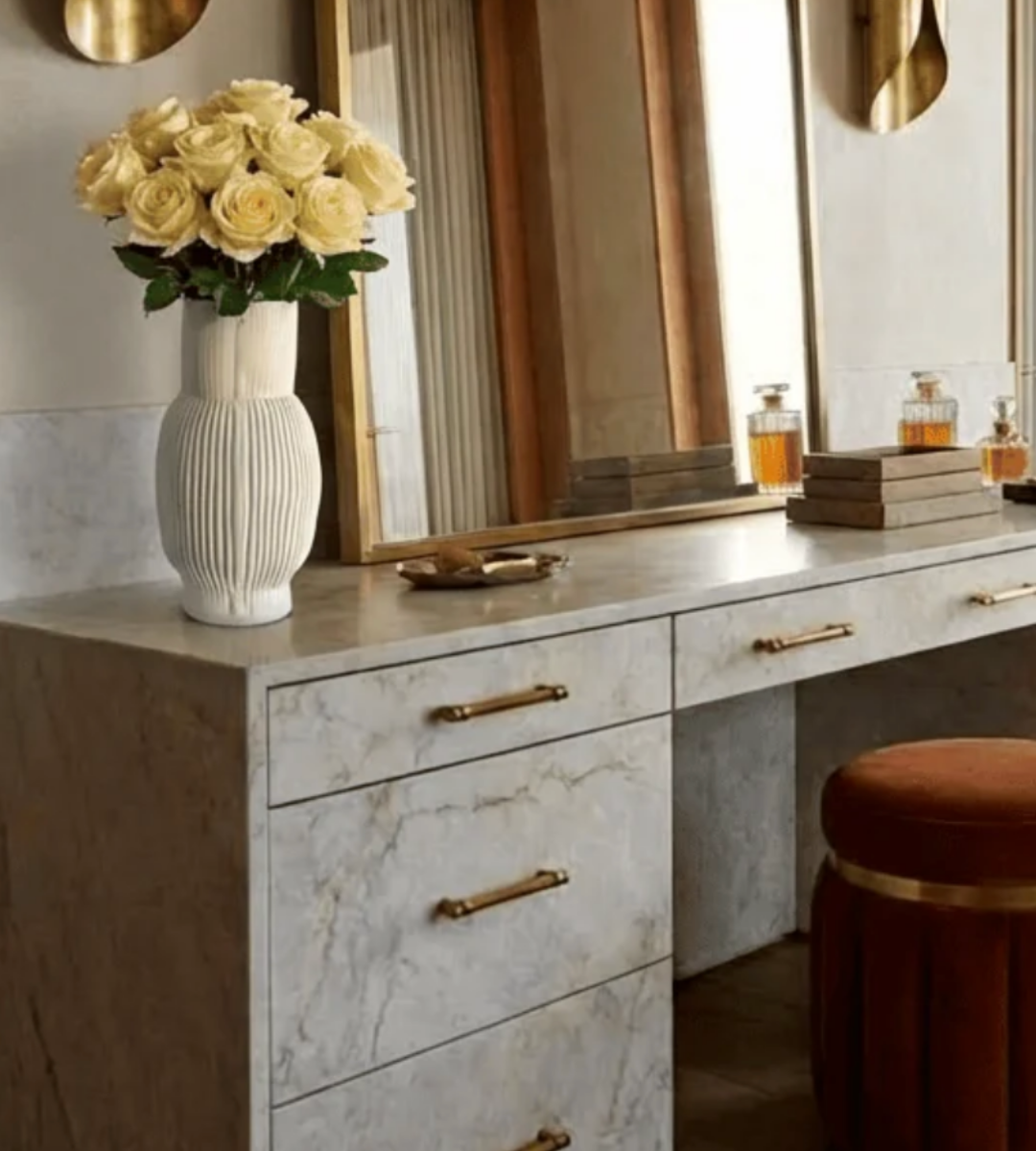 A vertically ribbed, off-white Frame Vase Cream filled with cream roses sits on a marble vanity.