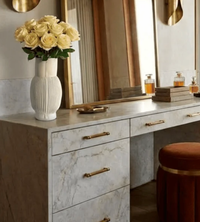 A vertically ribbed, off-white Frame Vase Cream filled with cream roses sits on a marble vanity.