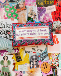 A vibrant bulletin board displays magazine cut-outs and stickers. At the center sits Furbish's Needlepoint Pillow - Control Freak, featuring the playful phrase: "I'm not a control freak but you're doing it wrong.