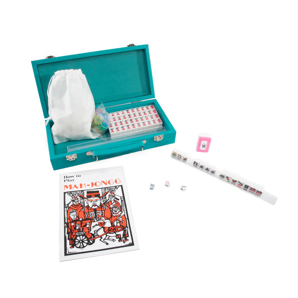 The Mini Travel Mahjong Set by Brouk & Co features a turquoise storage box, white tile racks, tiles, dice, a pink card holder, drawstring bag, and a rule book—perfect as a portable mahjong set for beginners and travel.