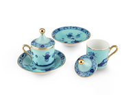 Two light blue Ginori 1735 Oriente Italiano Dinnerware Iris porcelain tea cups with matching saucers and lids, featuring blue chinoiserie floral patterns and gold rims.