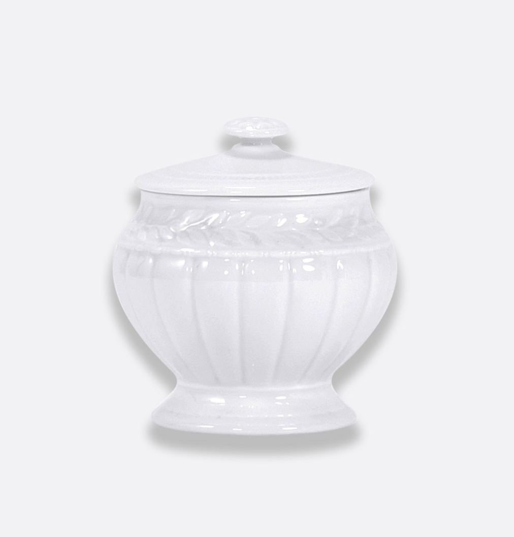Bernardaud’s Louvre Dinnerware sugar bowl in white ceramic, with a lid, showcases subtle embossed vertical lines and a refined floral pattern near the top inspired by Renaissance French architectural details, presented against a plain light gray background.