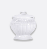 Bernardaud’s Louvre Dinnerware sugar bowl in white ceramic, with a lid, showcases subtle embossed vertical lines and a refined floral pattern near the top inspired by Renaissance French architectural details, presented against a plain light gray background.