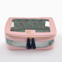 A stylish Mahjong Tile Storage Bag by Oh My Mahjong, featuring a pink exterior, clear top window, gold zipper, navy tassels, and a floral-patterned interior. The front is adorned with “OH MY MAHJONG” printed in gold, making this chic case an ideal organizer for effortless Mahjong tile storage.