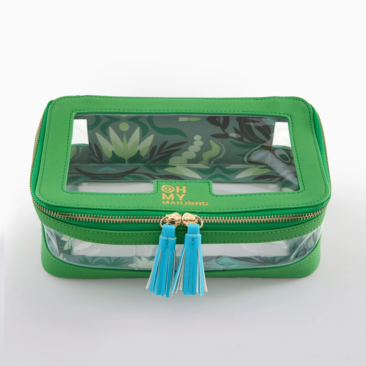 A green Mahjong Tile Storage Bag by Oh My Mahjong, featuring zippered closure with blue and white tassel pulls, transparent panels, and a decorative leafy interior lining. The stylish pouch is designed specifically for tile storage and displays a label that reads “OH MY MAHJONG.”.
