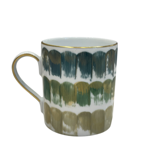 The Marie Daage Dahlia Dinnerware ceramic mug by Marie Daâge features gold-edged handles and brushstroke patterns in green, blue, and gold on white, adding a touch of luxury to your daily routine.