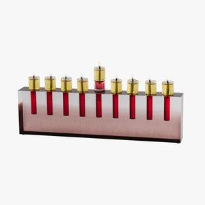 The Apeloig Modern Acrylic Oil Menorah features nine lit red and gold candle holders on a sleek rectangular metallic base, displayed against a white background.