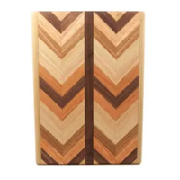 The Multiwood Herringbone Serving Board by Dickinson Woodworking features a rectangular shape with a striking chevron pattern crafted from alternating light and dark wood tones, divided by a central vertical strip.