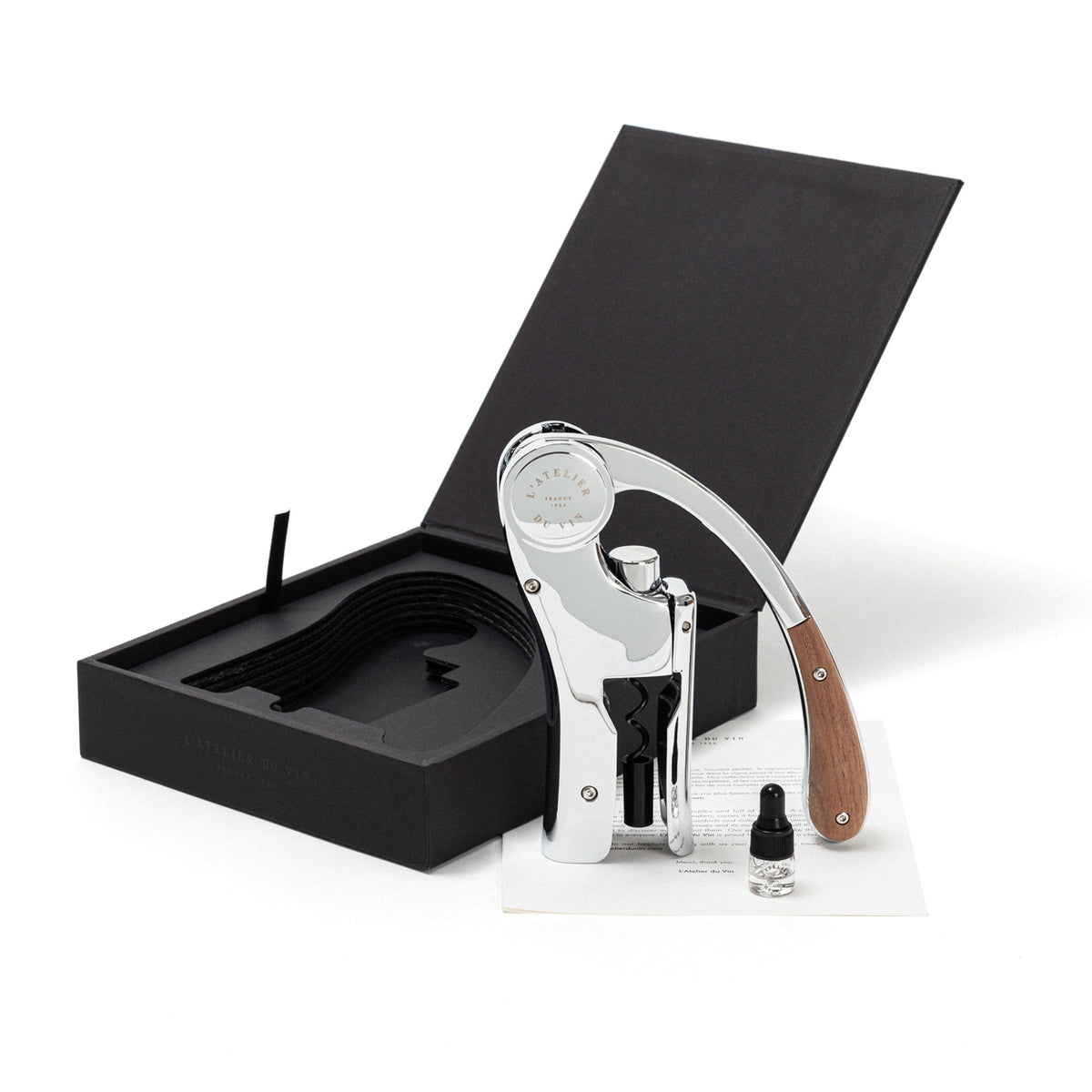 A L’ Atelier du Vin Lever Wine Opener - Silver with wooden handle details, displayed next to its open luxury gift box, a small glass vial, and a white information card.