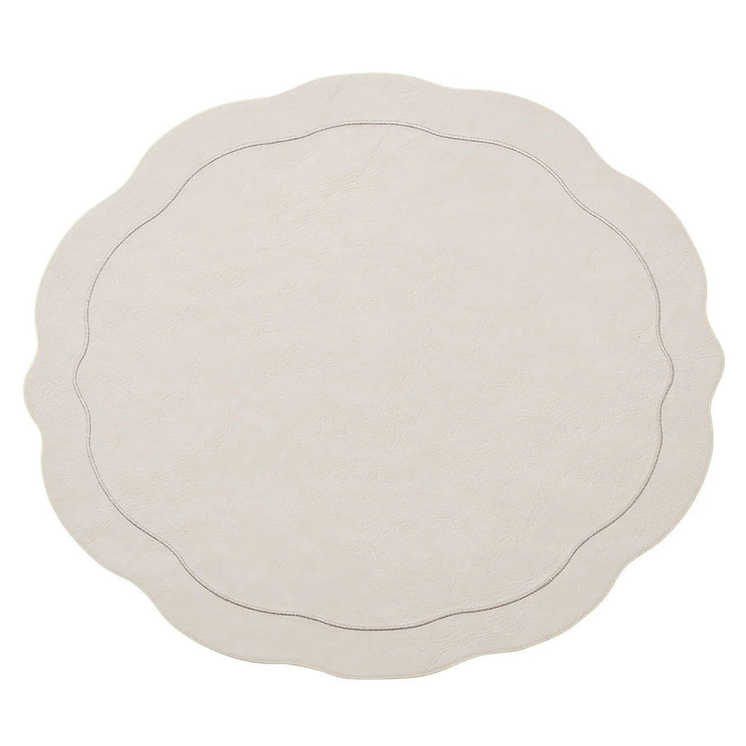 The Kim Seybert Tailored Placemat Set of 4 in Ivory features round, cream-colored faux leather mats with scalloped edges and a subtle stitched border, shown on a white background.