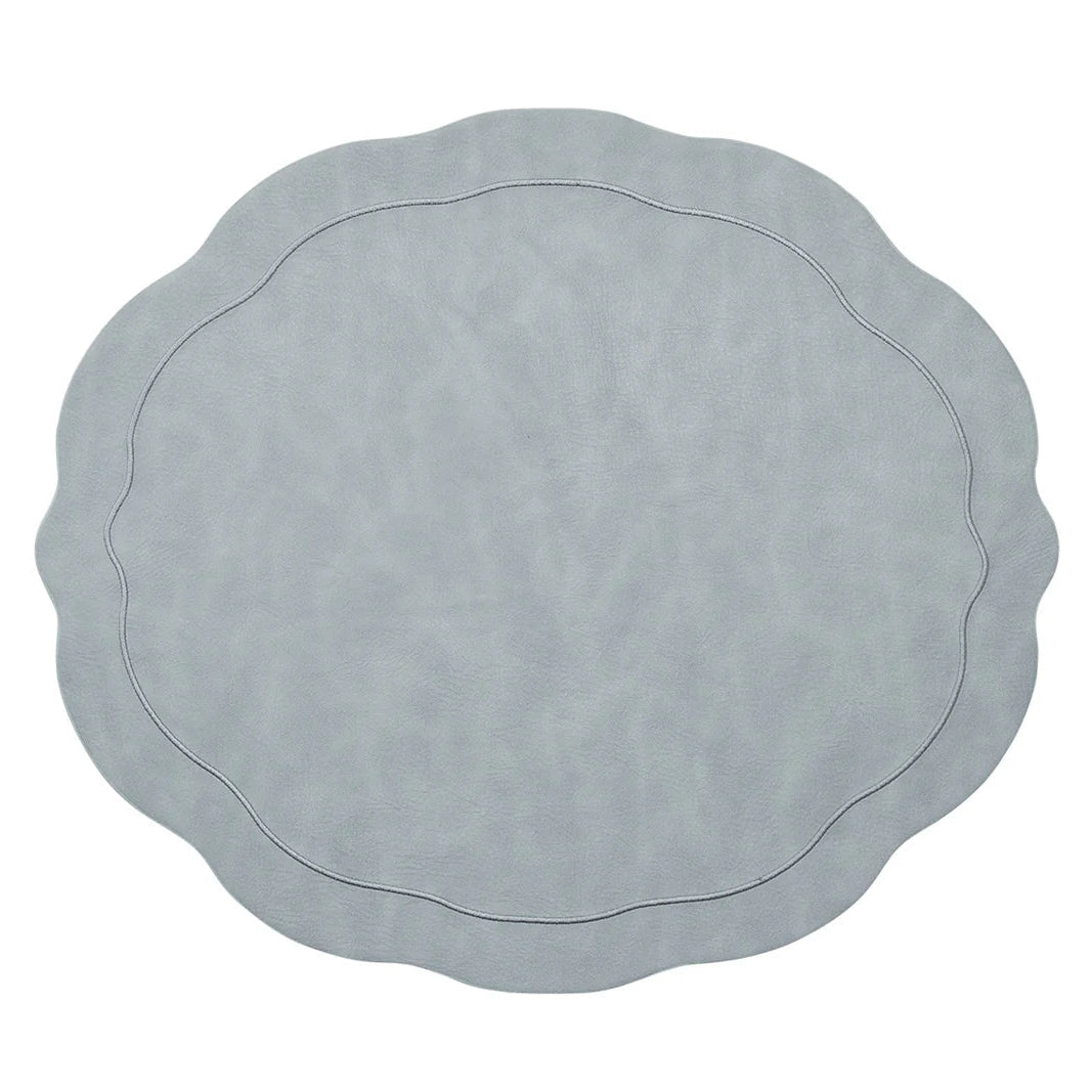 The Kim Seybert Tailored Placemat Set of 4 in Steel Grey features a light steel gray color, wavy edges, a subtle textured pattern, and an oval-shaped embossed border near the center.