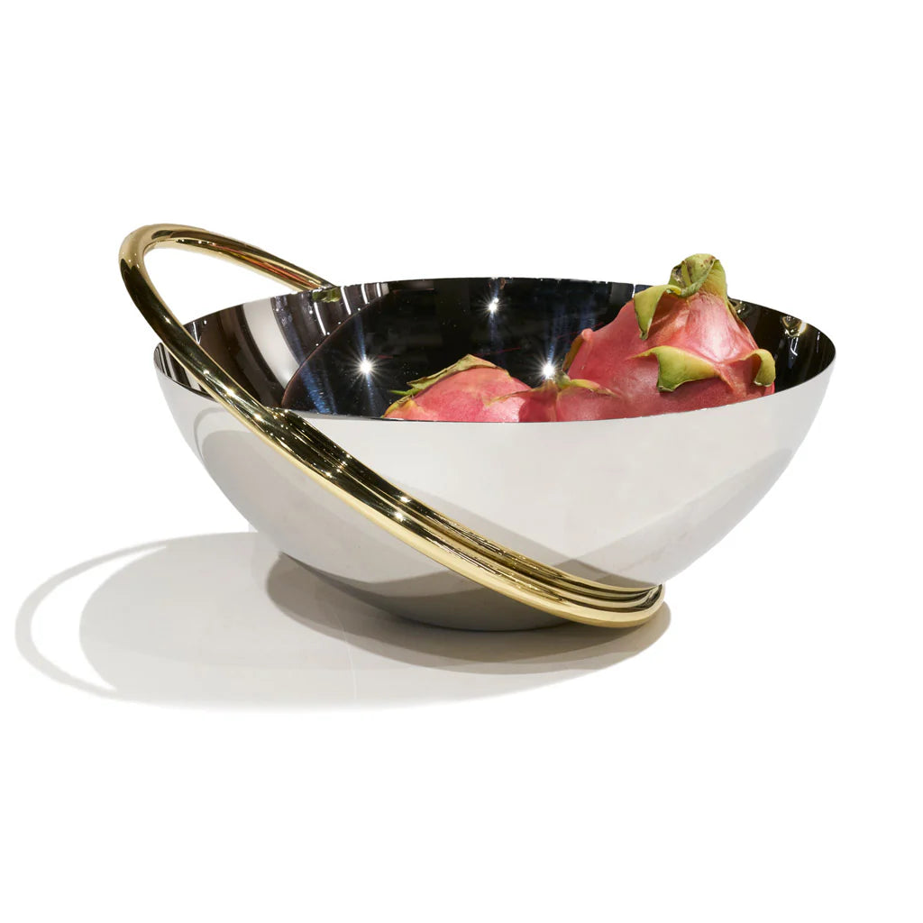 The Ring Fruit Bowl by Anna New York, featuring reflective stainless steel and a gold circular handle, holds two pink dragon fruits as a striking centerpiece on a plain white background.