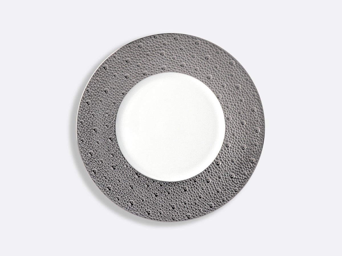 Featuring a round plate from Bernardaud’s Ecume Platinum Dinnerware collection, this piece showcases a textured, dark gray rim and a smooth white center—presented on a light gray background—to bring contemporary flair and timeless elegance to your table setting.