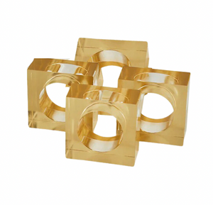 The Tizo Lucite Cube Napkin Ring Set of 4 features gold-colored, square acrylic rings with large circular cutouts—elegant accents to elevate your modern table decor.