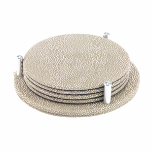 The Bodrum Stingray Coaster Set of 4 features textured, round beige coasters with a subtle metallic finish, stacked neatly in a matching holder with three vertical pegs for secure, stylish storage.