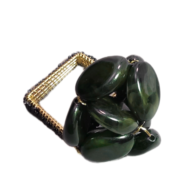 The Pebbles Napkin Ring Set of 4 by Iza Silva features chunky gold-tone woven square bands topped with clustered large dark green oval beads, evoking sculptural elegance for a luxurious table setting.