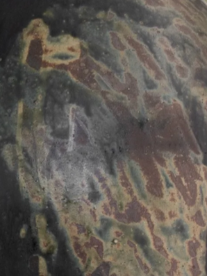 A close-up of the Devenir 1 Vase by CDMX / MASA TALLER reveals a weathered, rusted metal surface with patches of green, brown, and black—bearing the marks of corrosion and oxidation that evoke artisanal sculptural techniques.
