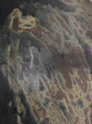 A close-up of the Devenir 1 Vase by CDMX / MASA TALLER reveals a weathered, rusted metal surface with patches of green, brown, and black—bearing the marks of corrosion and oxidation that evoke artisanal sculptural techniques.