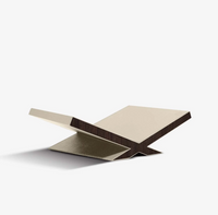 A modern, minimalist “Culture Bookstand - Stone” by Assouline, featuring two intersecting boards that form an X shape, displayed on a plain white background.