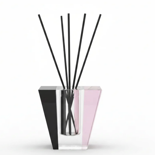 The Solar Prism Crystal Diffuser - Onyx & Rose - Elder Flower by Frave Home features a modern geometric crystal vessel with clear, pink, and black accents. Several thin black reeds stand upright against a white background, creating an elegant design perfect for infusing your space with the enchanting aroma of Elder Flower.