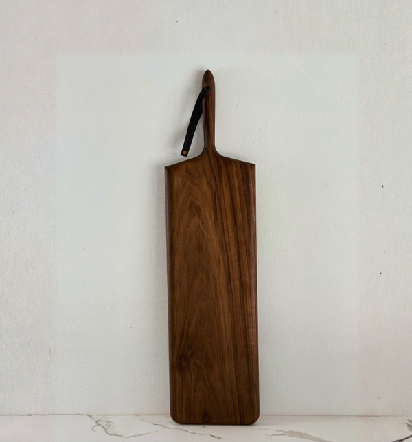 Long rectangular Khem Long Rectangle Monster Serving Board in walnut hardwood with a handle and a hanging strap.