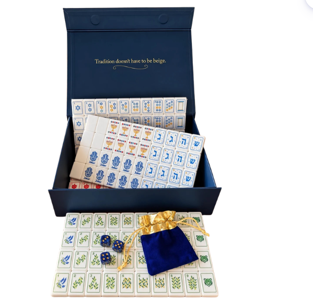 Eclectic Judaica Brilliant Nights Hanukkah Mahjong Tile Set in an open blue gift box, featuring acrylic tiles with Hanukkah-themed designs, a velvet drawstring pouch, and two blue dice.