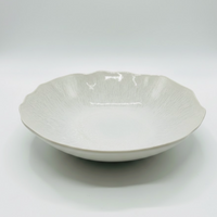 The Plume White Dinnerware Pearl by Jars - Rosenthal, shown against a white background, features a scalloped edge, subtle textured pattern, and shallow wide shape inspired by elegant ceramic design.
